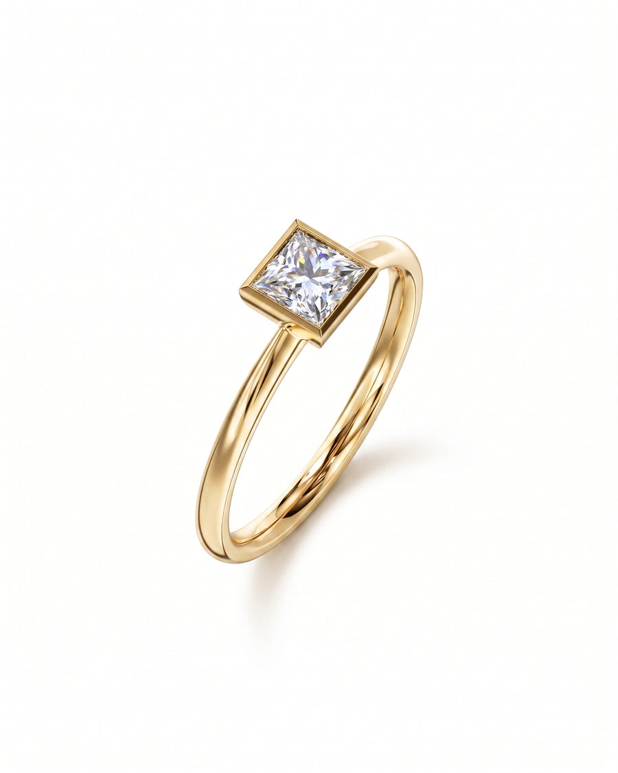 Yellow gold engagement ring with a princess cut diamond in a bezel setting.