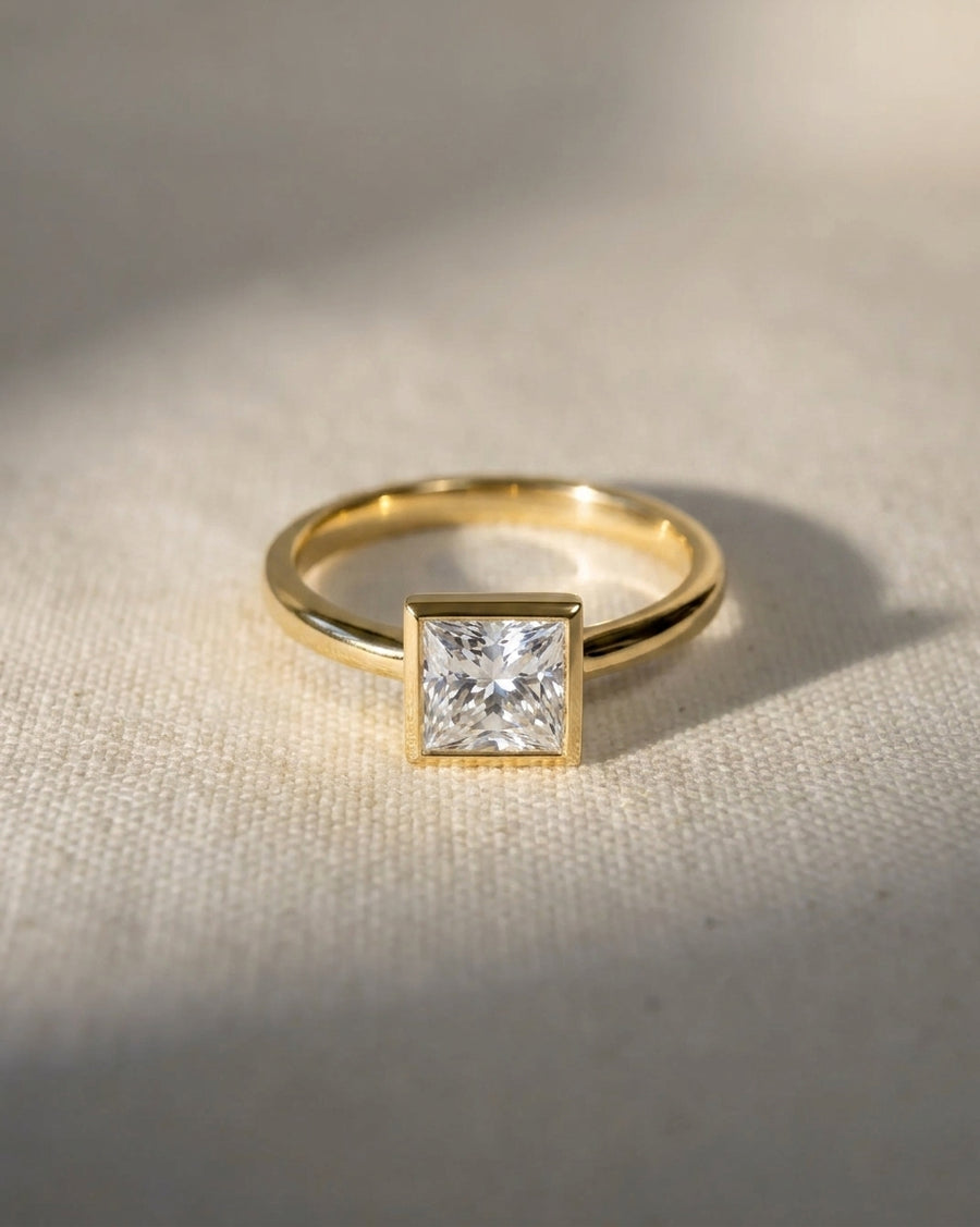 18ct yellow gold engagement ring with a 1ct princess cut lab-grown diamond in a bezel setting.