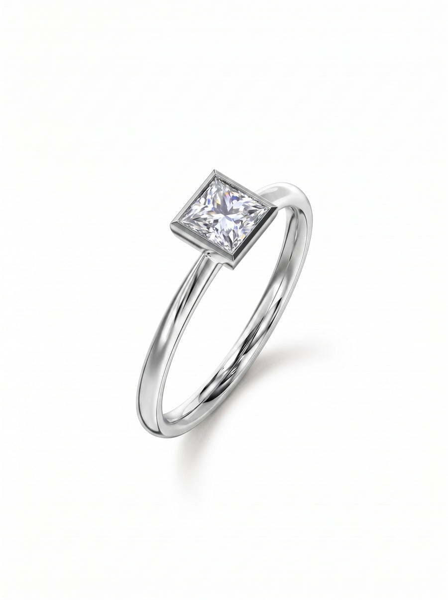 Princess cut diamond engagement ring in a silver-toned bezel setting on a polished metal band.
