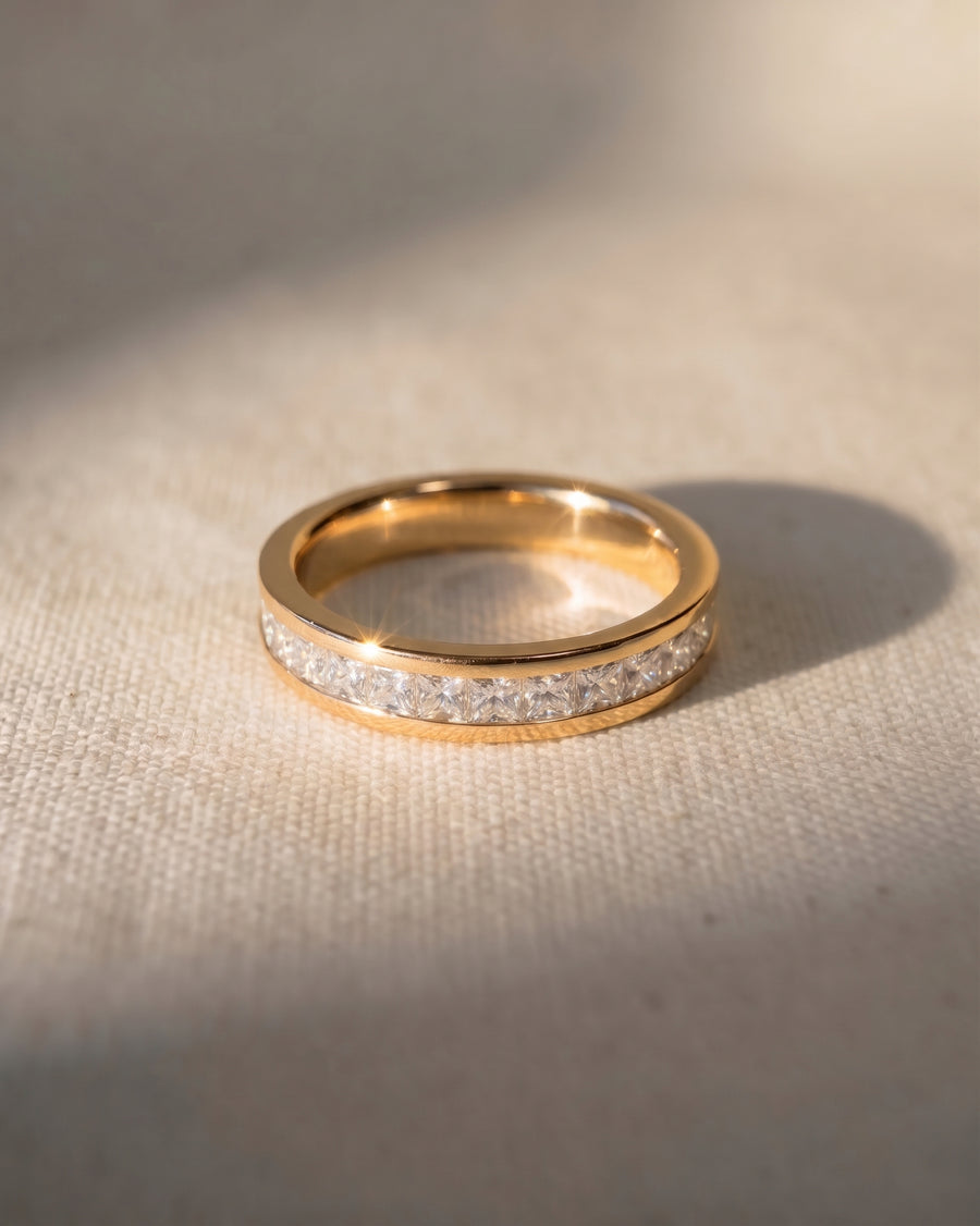 Gold eternity ring with princess cut channel set diamonds.
