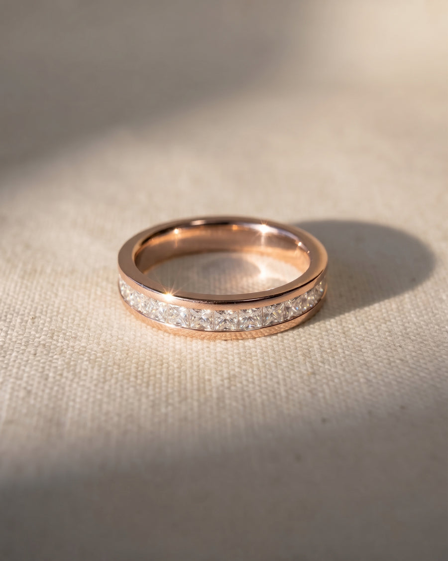 Rose gold eternity ring with princess cut channel set diamonds.