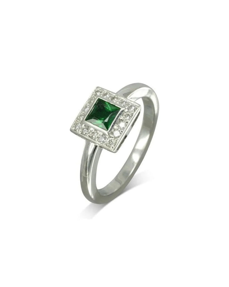 Platinum ring with a princess cut emerald and diamond cluster.