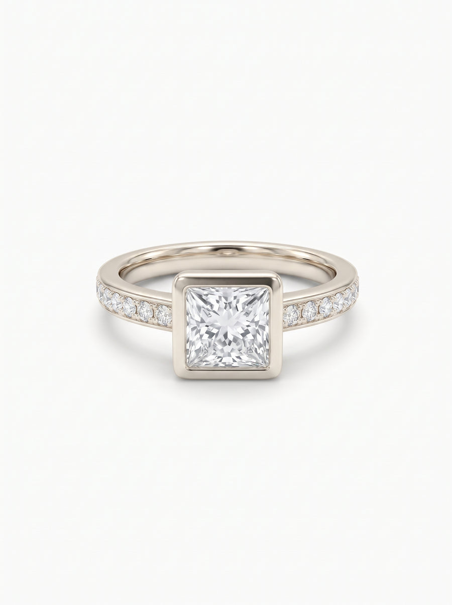 Princess cut diamond engagement ring in a gold bezel setting with pavé diamonds on the band.