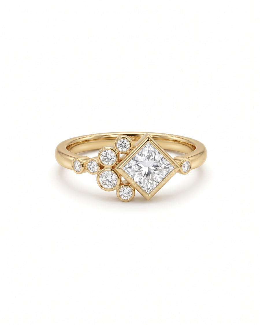 Gold engagement ring featuring a princess cut center diamond and a cluster of small round accent diamonds.