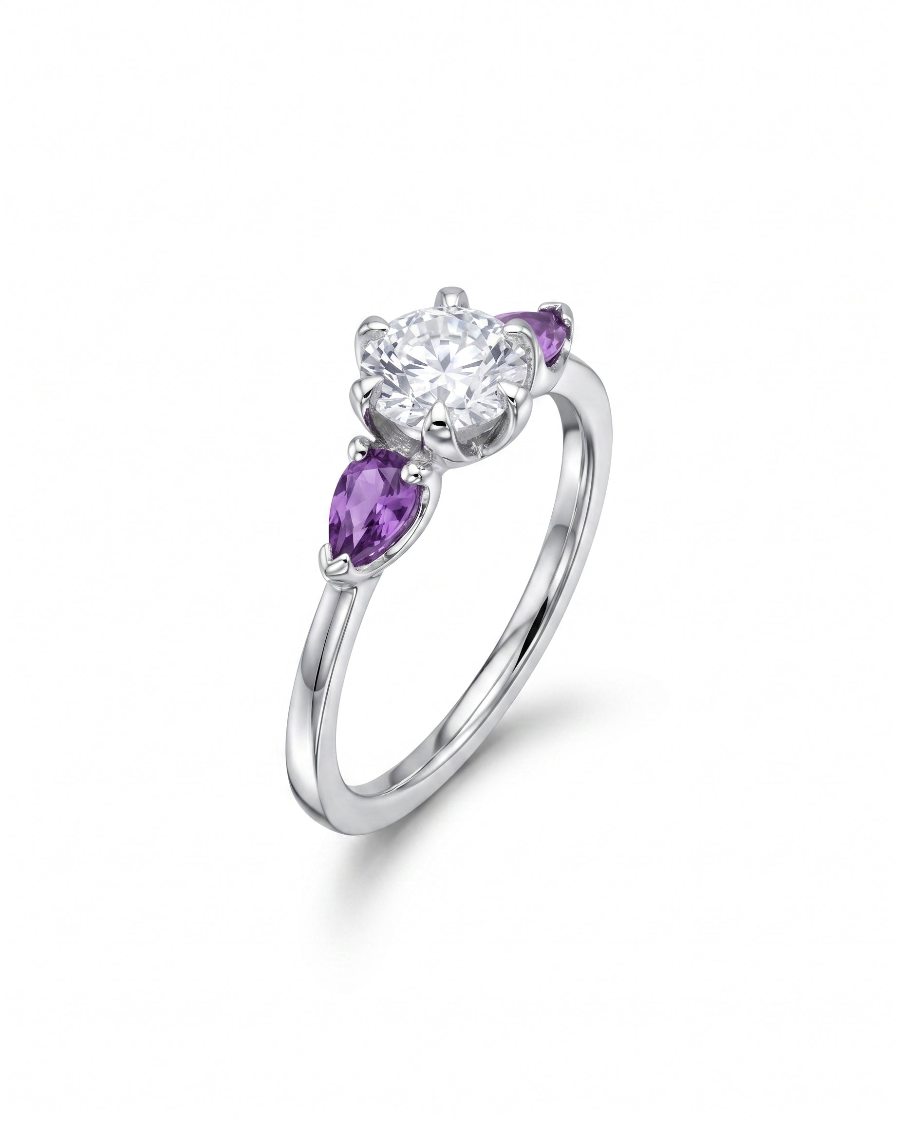 Silver ring with a round diamond flanked by two pear-shaped purple sapphires.