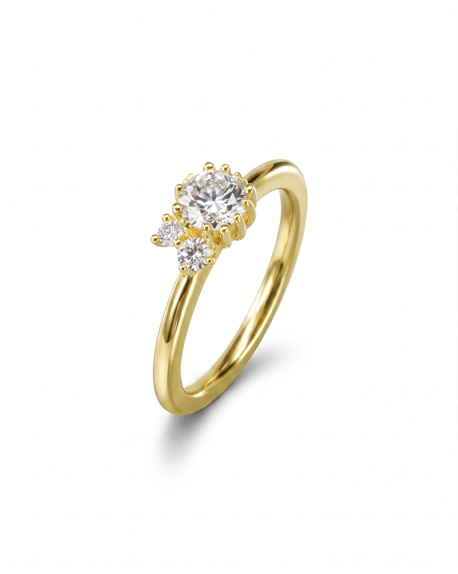 Gold engagement ring with a central diamond and two smaller side diamonds.