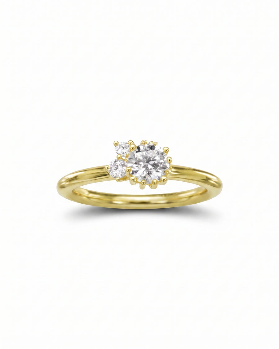Gold engagement ring with a random claw cluster diamond design.