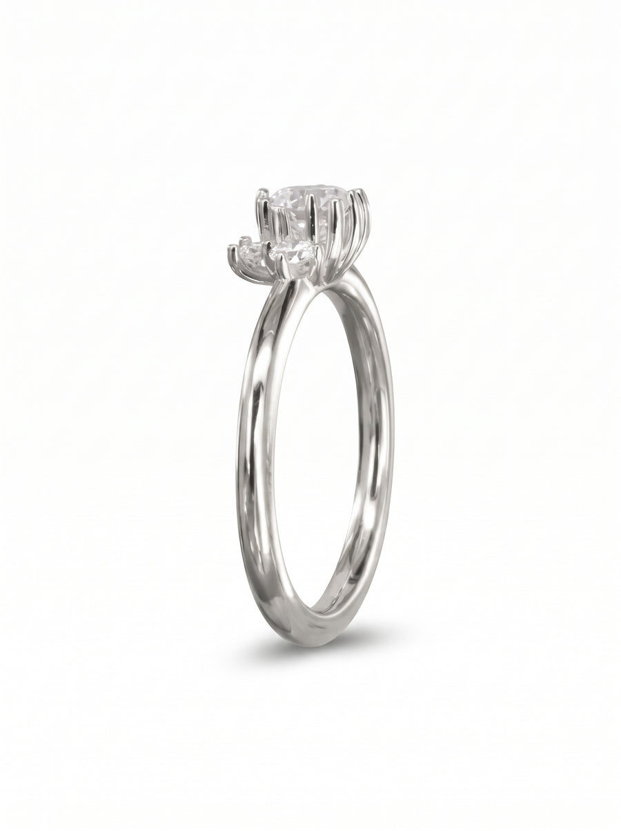Silver engagement ring with a random cluster of round diamonds in claw settings on a polished band.