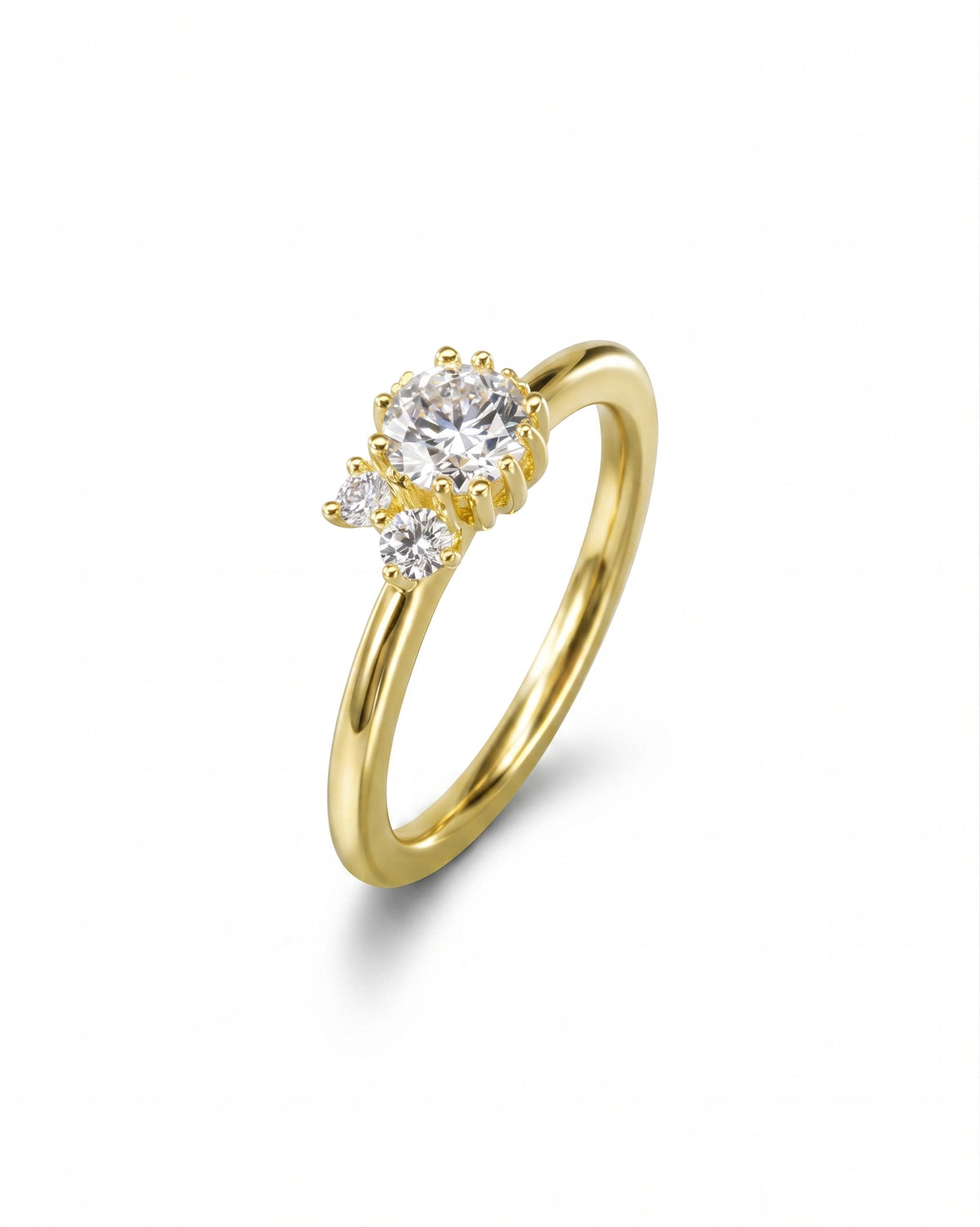 Gold engagement ring featuring a cluster of three round diamonds in a claw setting on a smooth band.