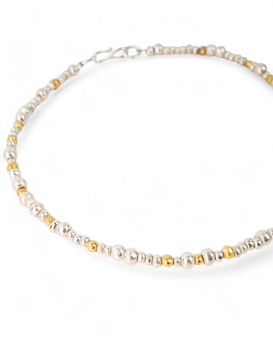 Handmade necklace with mixed silver and gold nugget beads on a white background