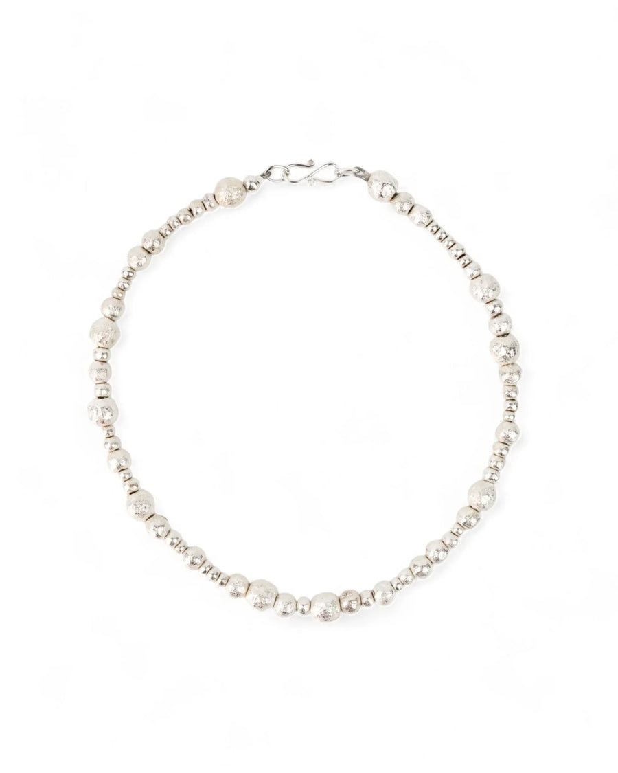 Handmade silver beaded necklace with organic, textured nuggets on a white background