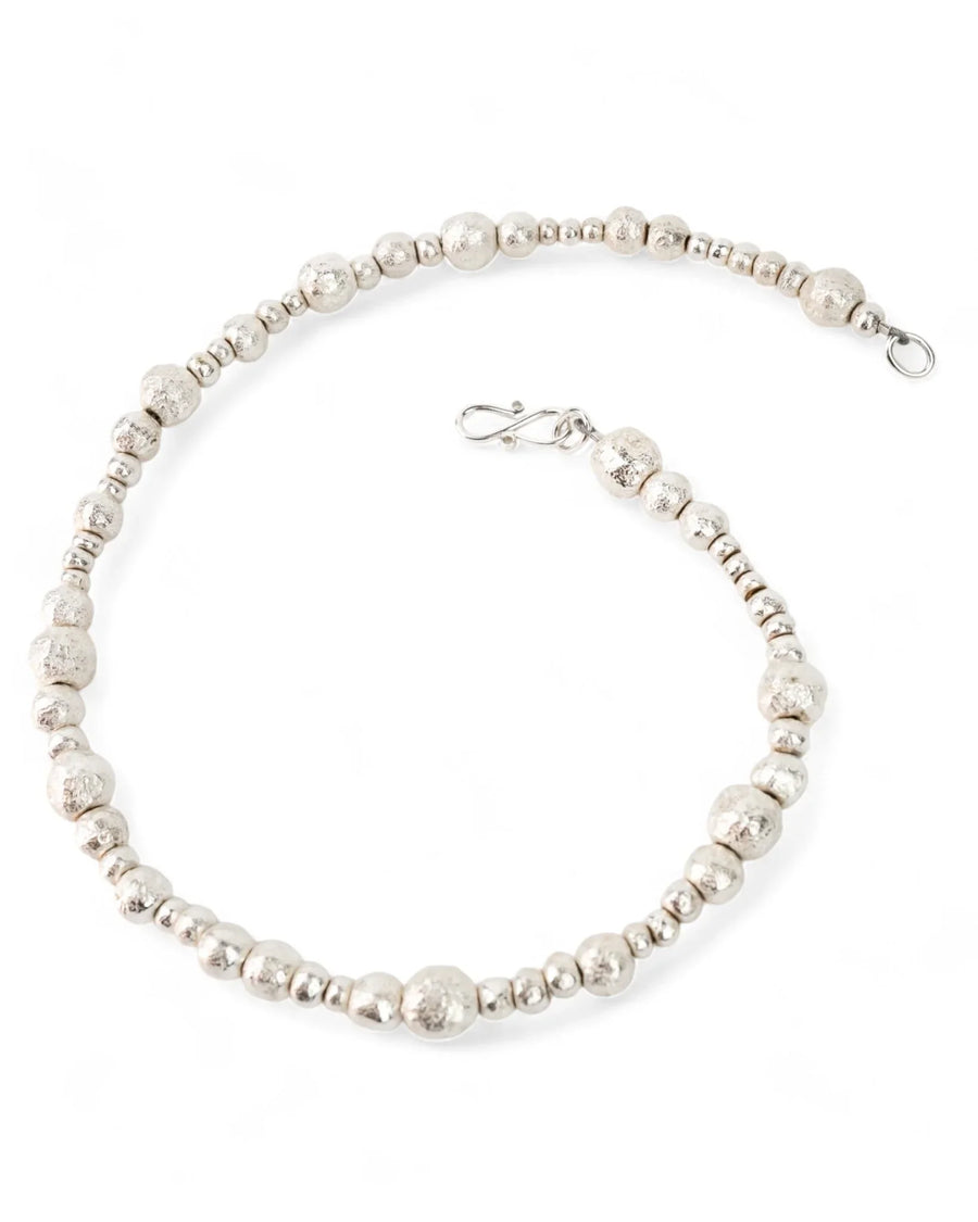 Handmade silver nugget beaded necklace with organic textured beads on a white background