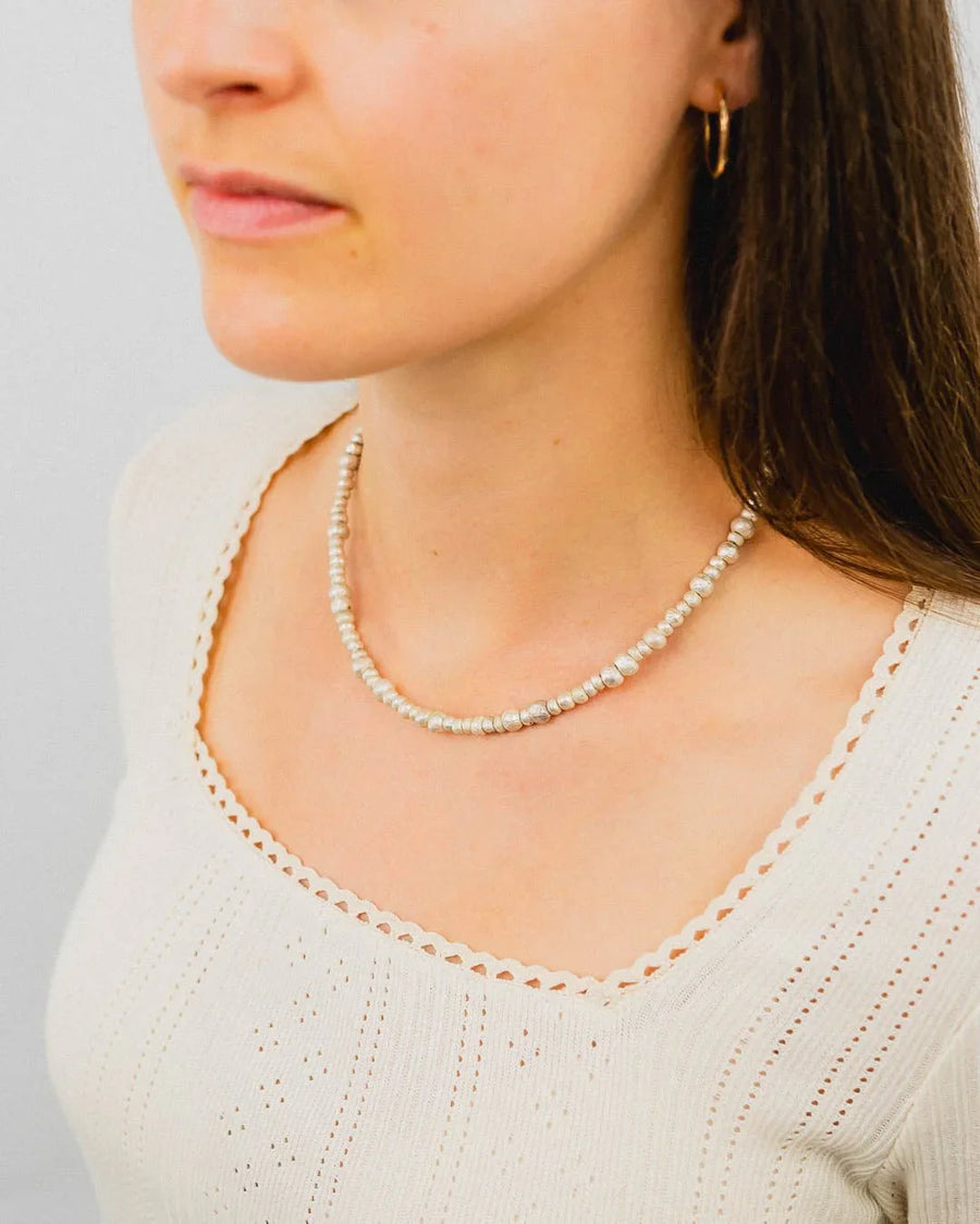 Woman wearing a handmade silver nugget necklace with organic, textured beads