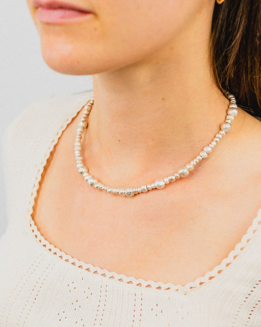 Organic silver nugget necklace with textured beads on a woman, handmade jewellery