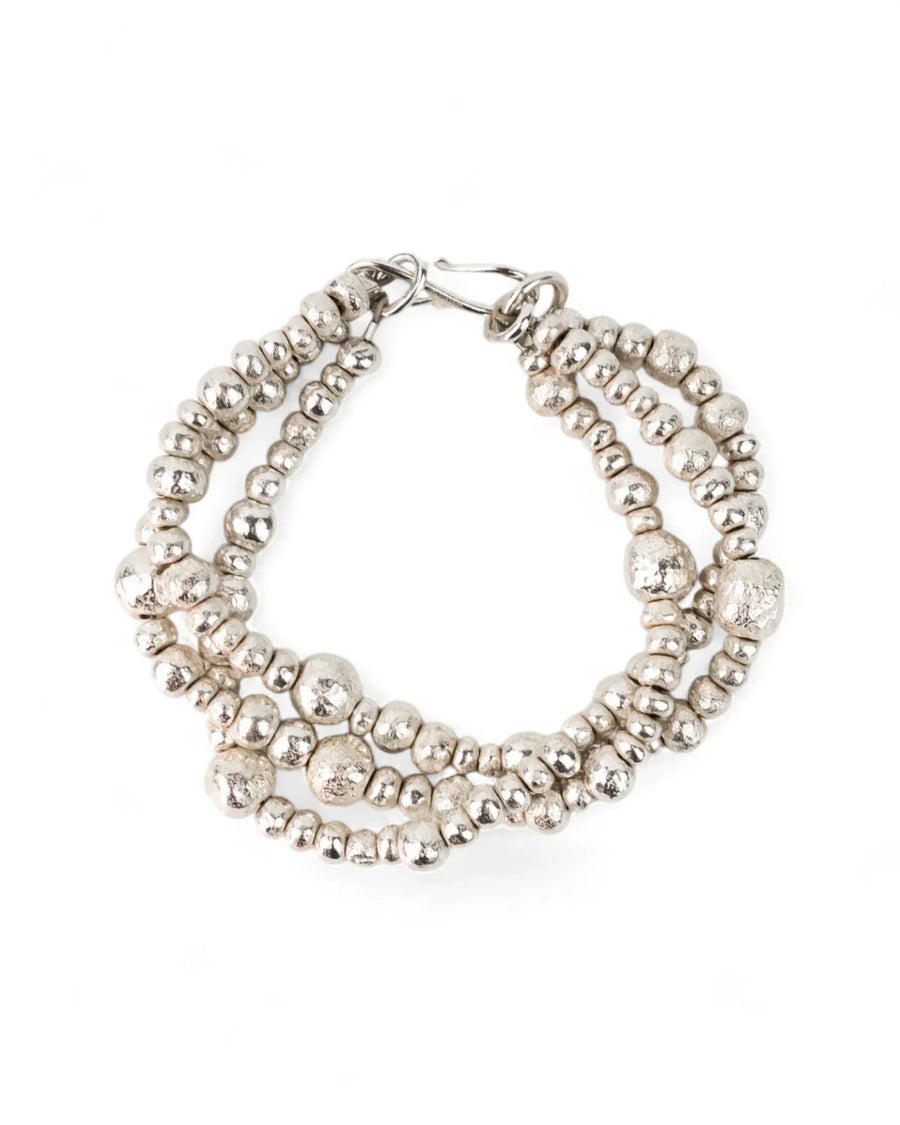 Handmade silver bracelet with triple twisted strands and organic nugget beads on white background