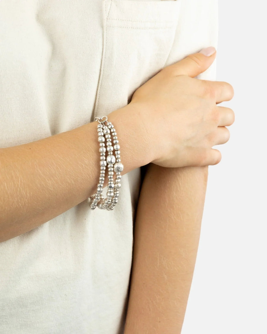 Triple strand silver beaded bracelet with organic nugget accents on wrist