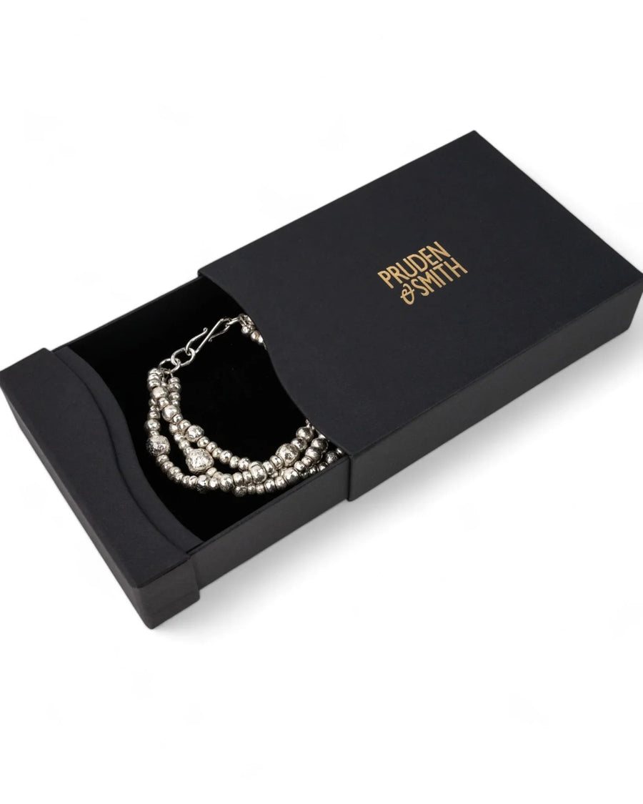 Triple twisted silver nugget bracelet with organic beads in a black gift box
