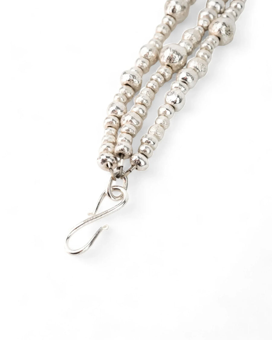 Handmade silver triple twisted nugget bead bracelet with textured finish on white background