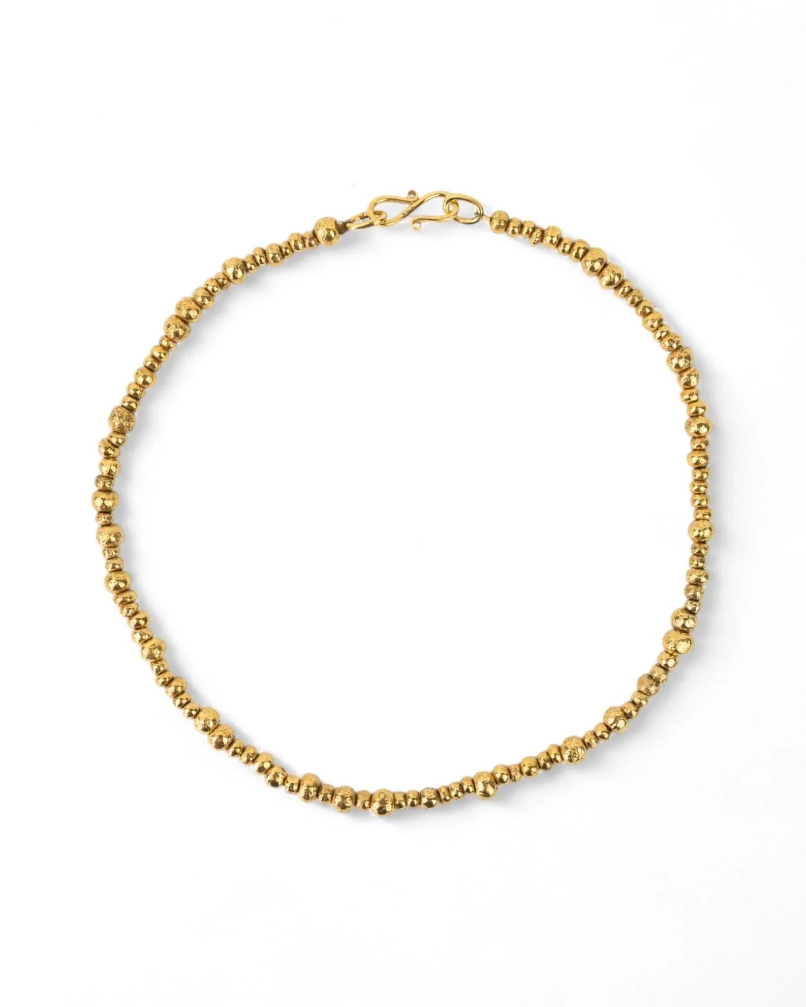 Yellow gold necklace with textured nugget beads on a white background