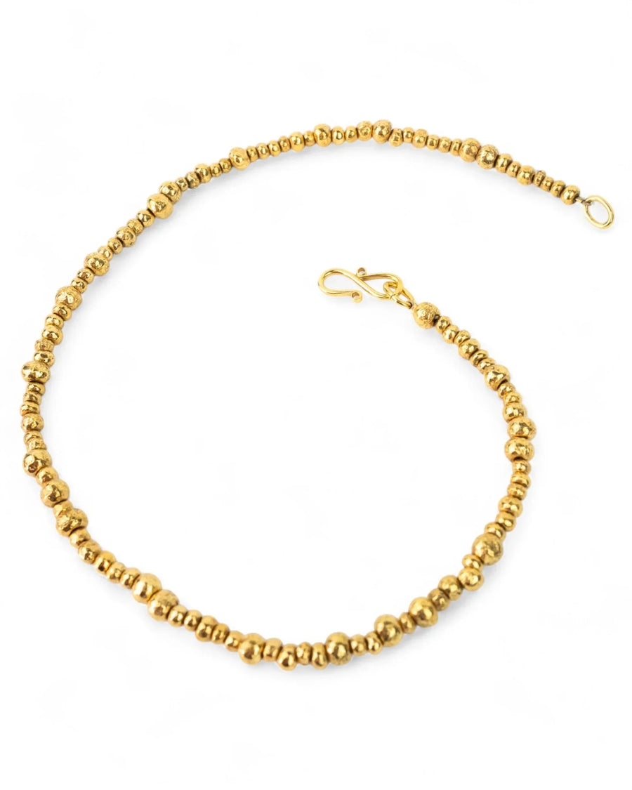 Yellow gold nugget necklace with organic textured beads on a white background