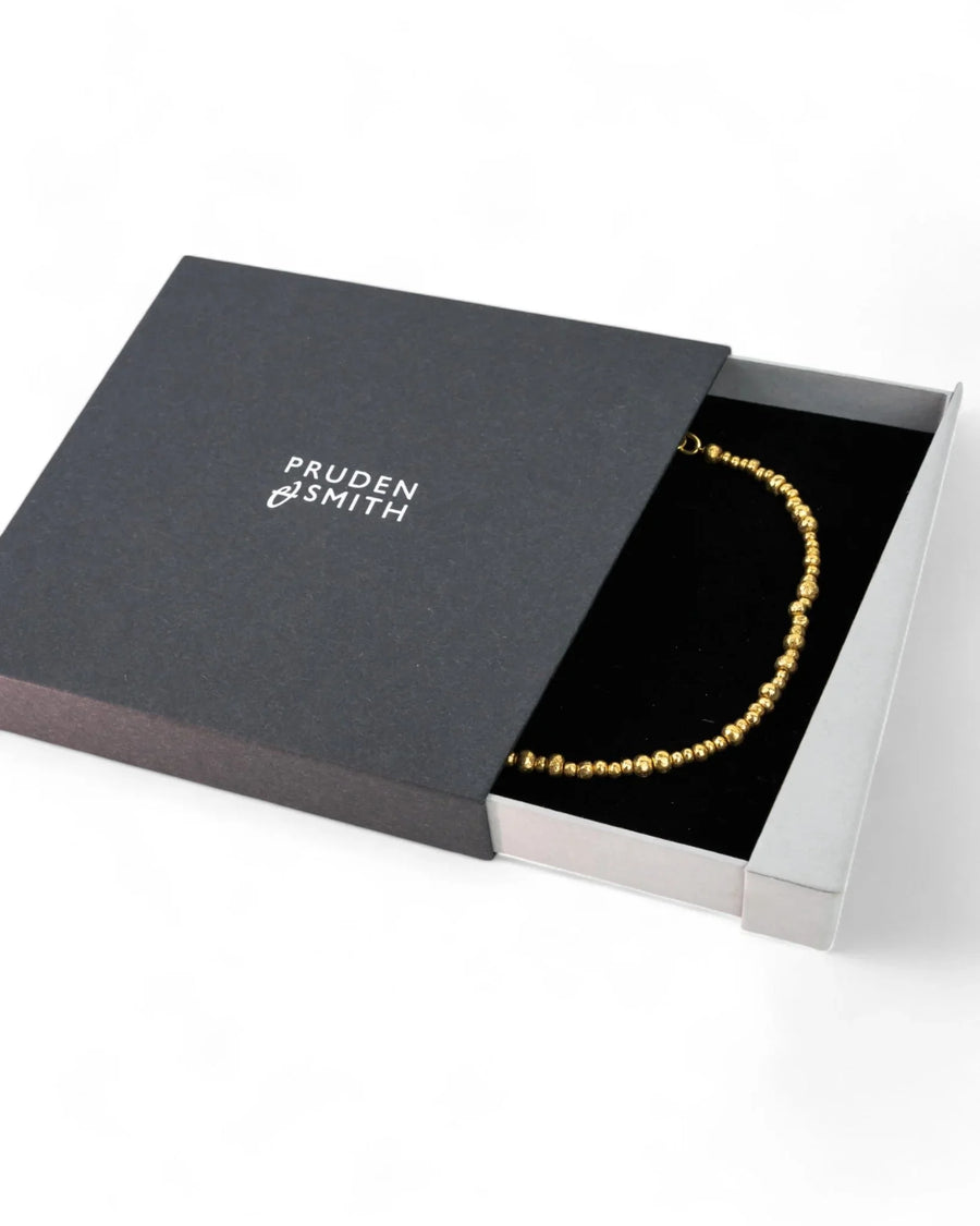 Yellow gold nugget bead necklace with organic texture in a black gift box