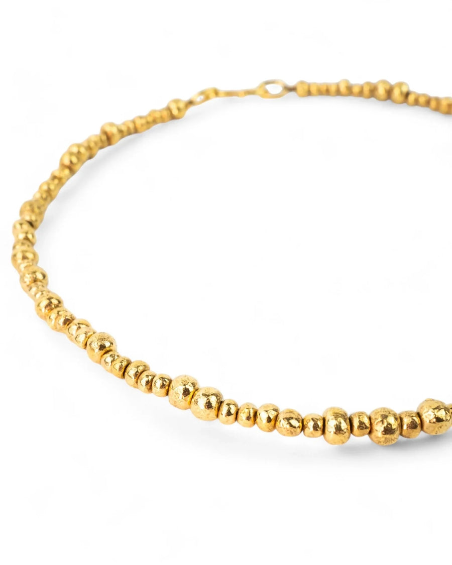 Yellow gold necklace with organic nugget beads on white background