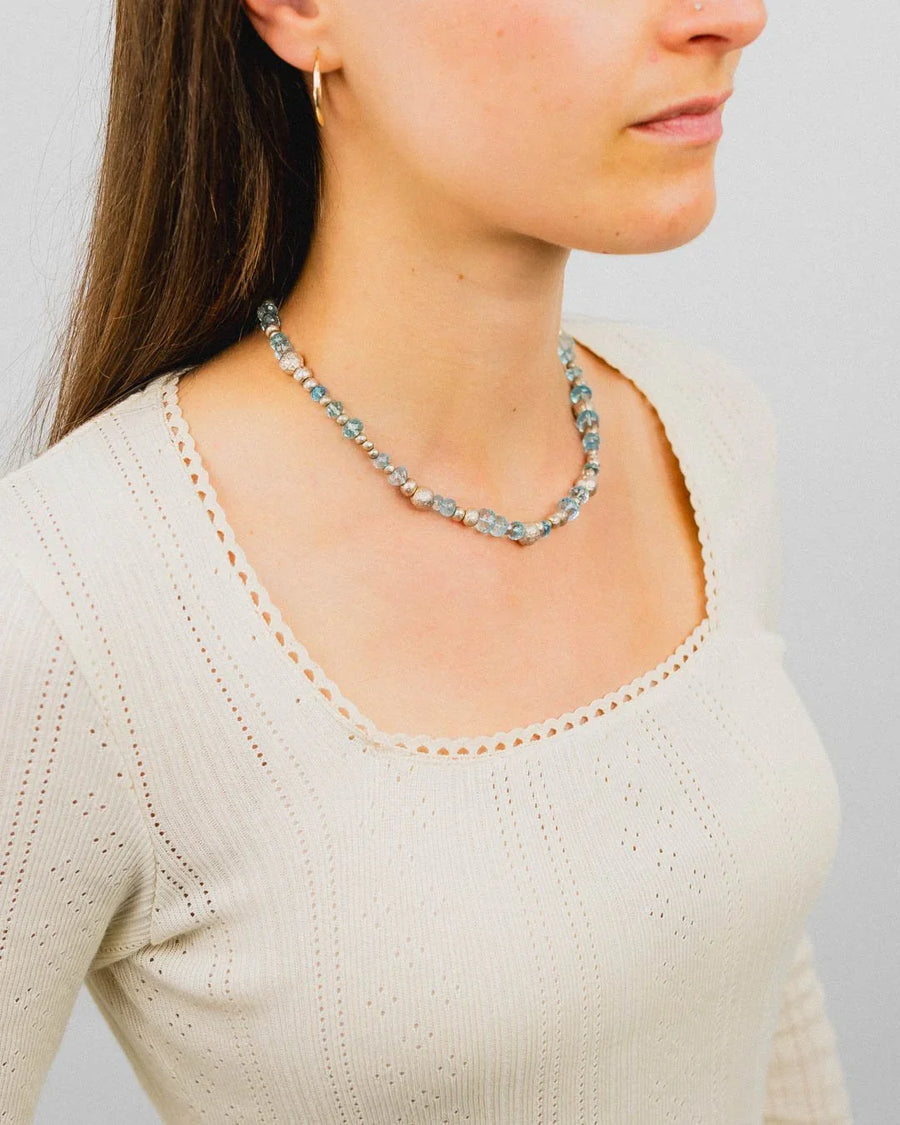 Woman wearing a handmade silver nugget and blue topaz beaded necklace