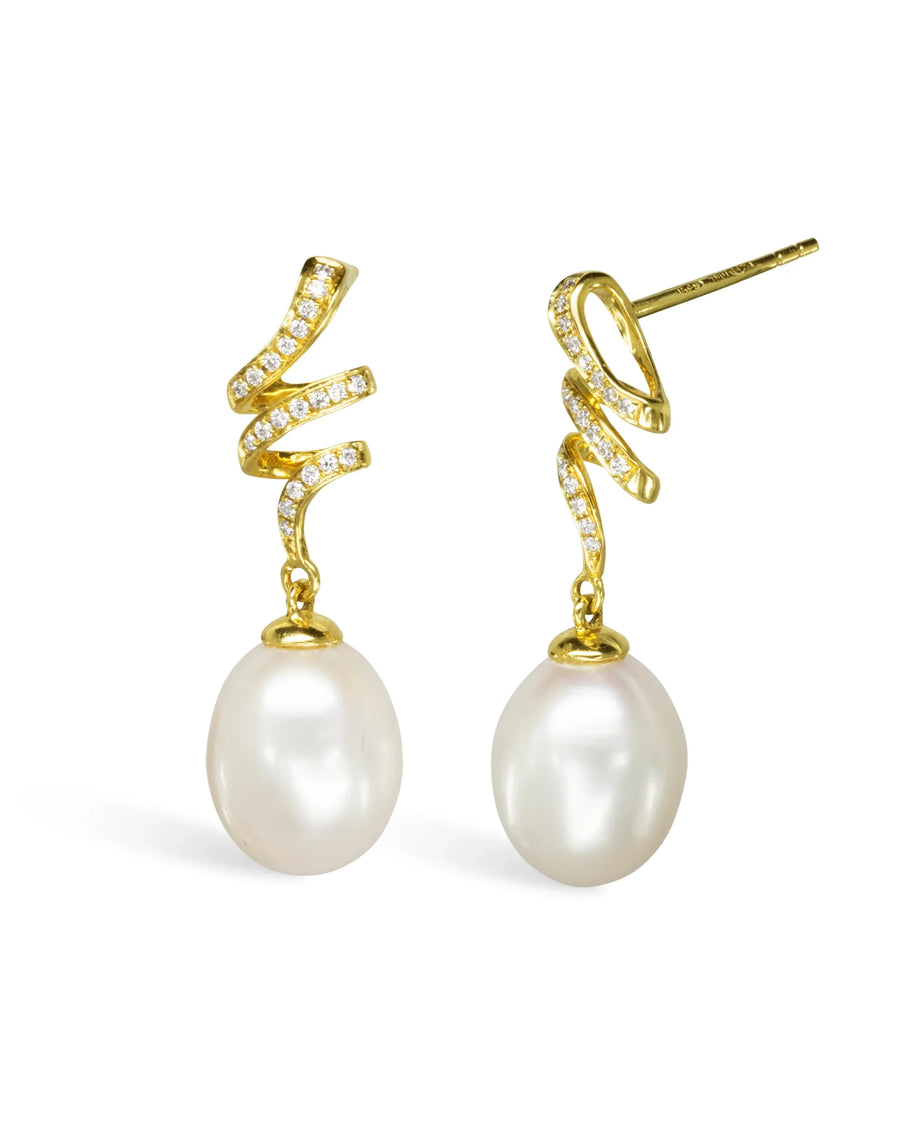 Gold swirl earrings with pavé diamonds and large drop pearls on white background