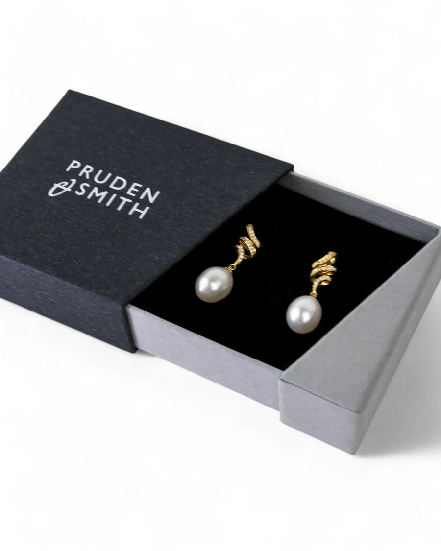 Gold drop earrings with pearl and diamond accents in a gift box
