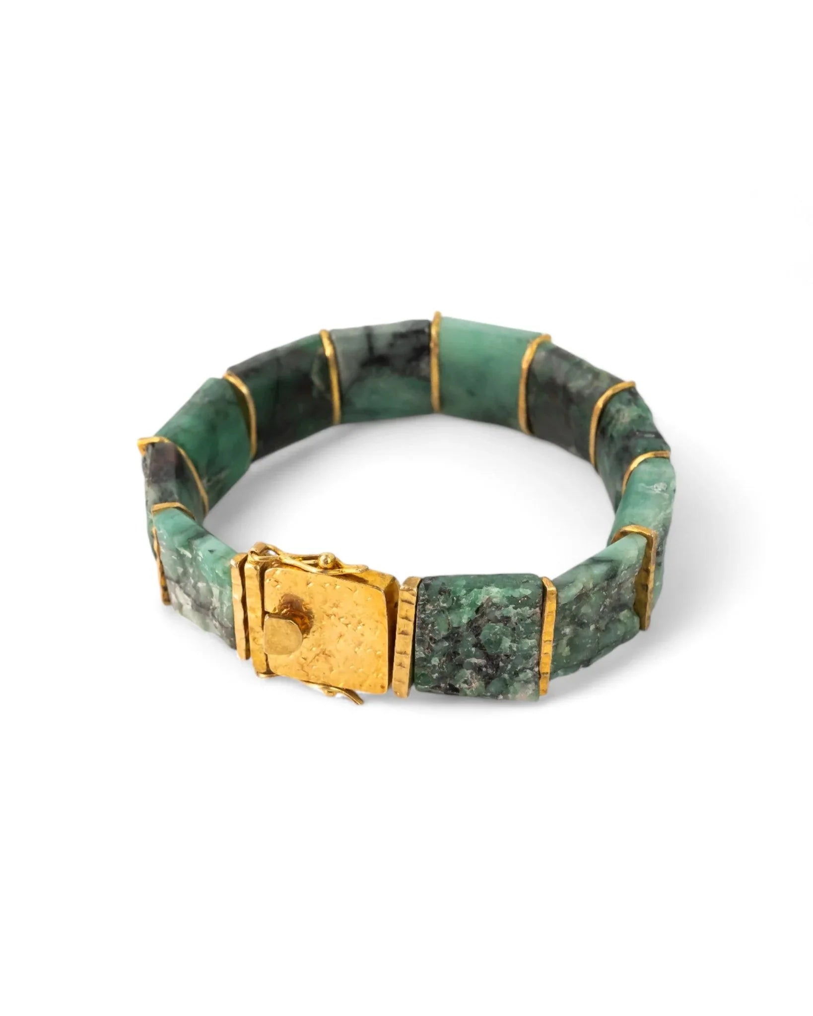 Chunky bracelet with rough Brazilian emerald stones and textured gold clasp on white background