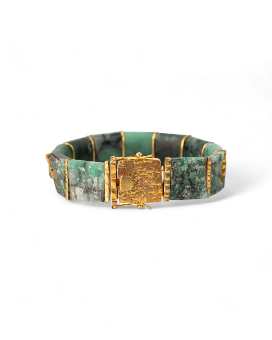 Rough Brazilian emerald bracelet with chunky gold links and textured clasp on white background