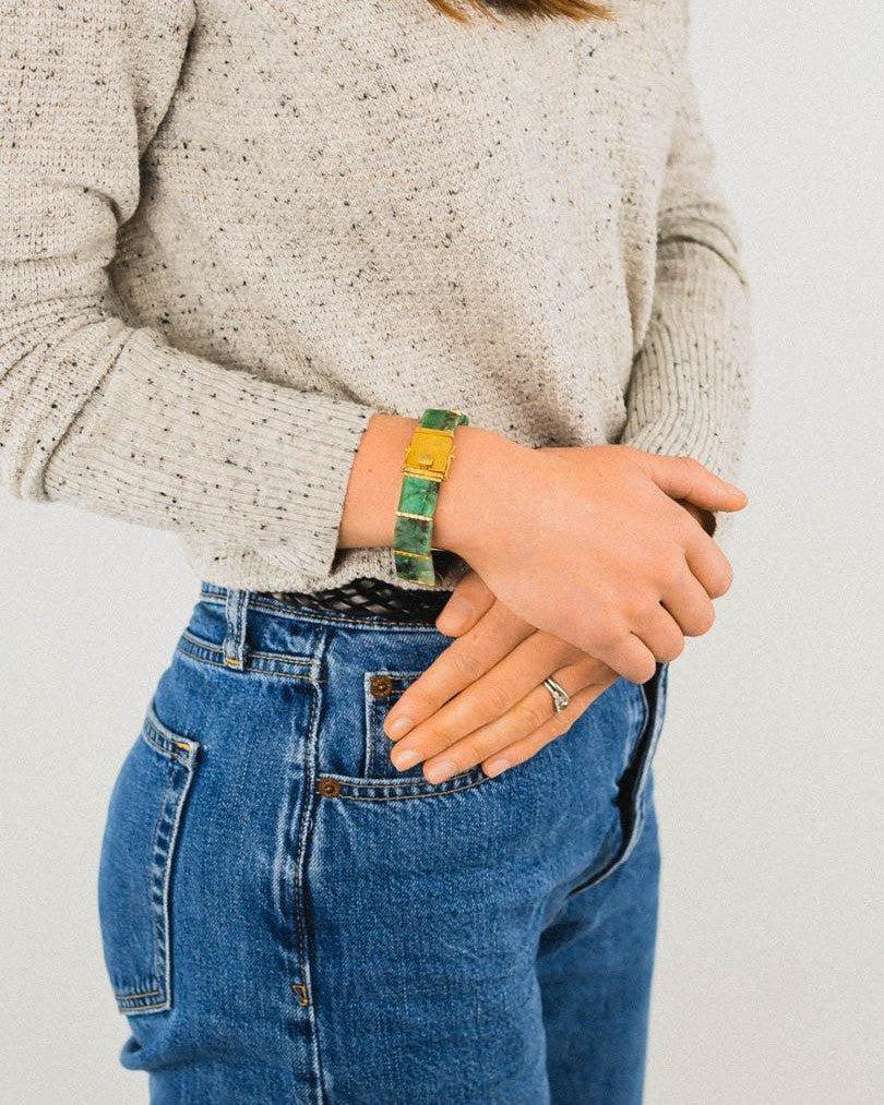 Woman wearing a rough-cut Brazilian emerald and gold bracelet with a casual outfit
