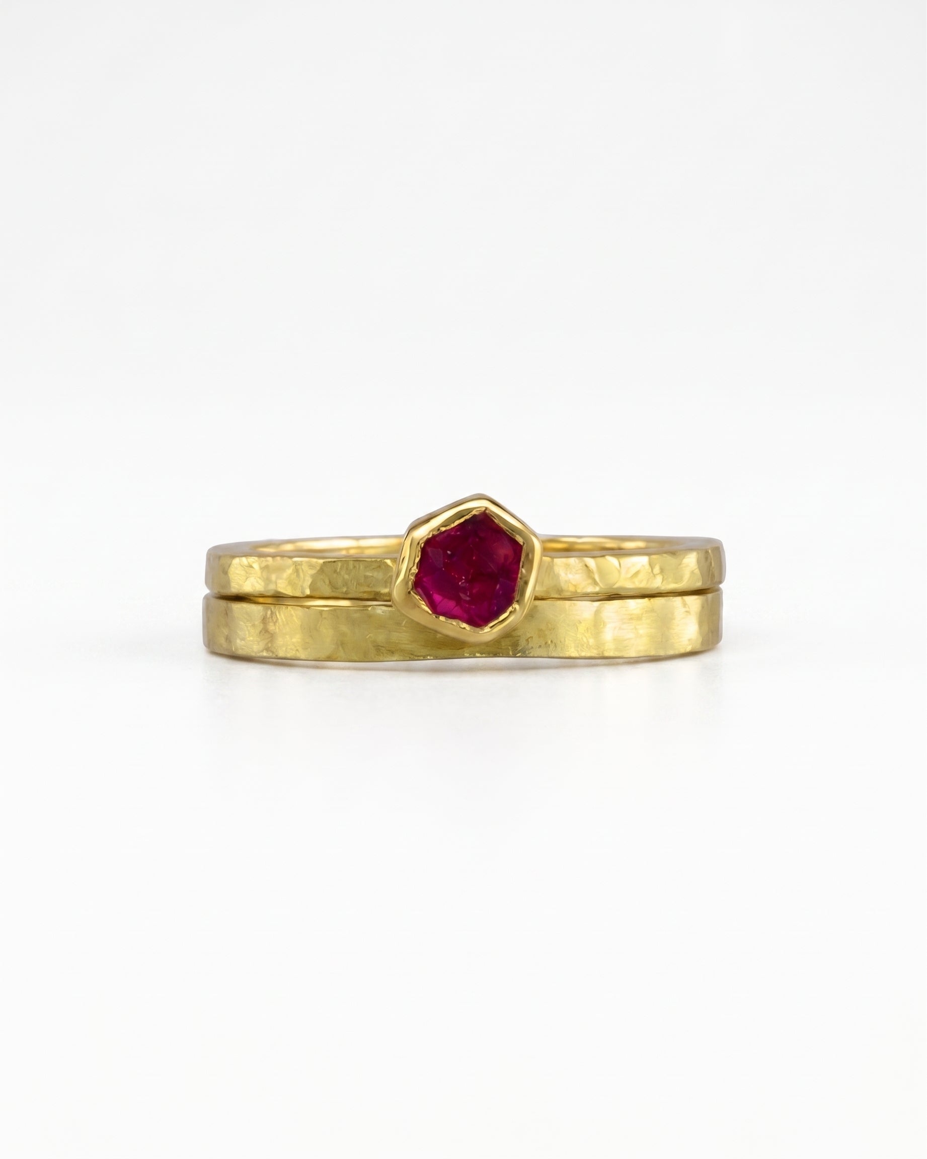 Rough cut ruby yellow gold ring set with a hexagonal ruby.