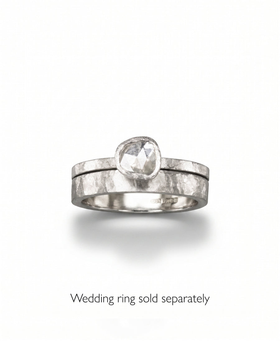 Silver engagement ring with a rough diamond, stacked on a textured silver band.