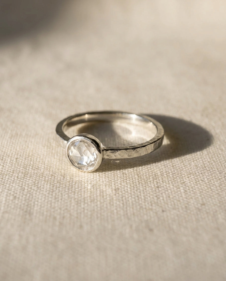 Silver engagement ring with a round rough diamond.