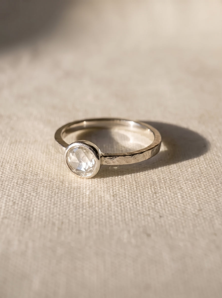 9ct white gold engagement ring with a 4-5mm bezel-set rough diamond on a textured band.