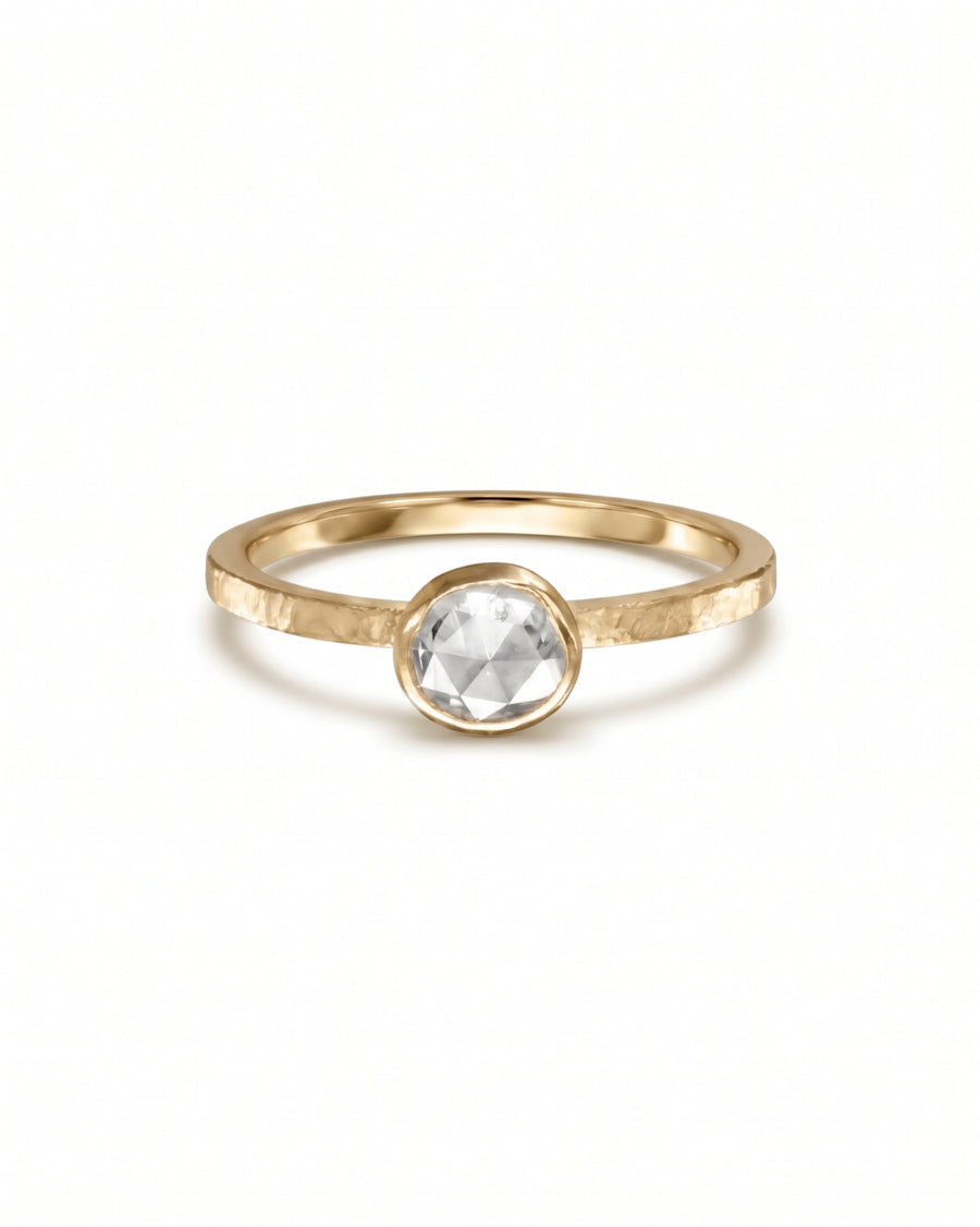 Bezel-set rose cut diamond ring on a hammered yellow gold band.