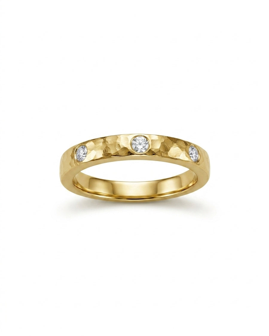 Rough hammered gold ring with three round diamonds.