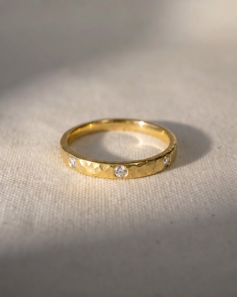 Gold rough hammered diamond ring with four round diamonds.