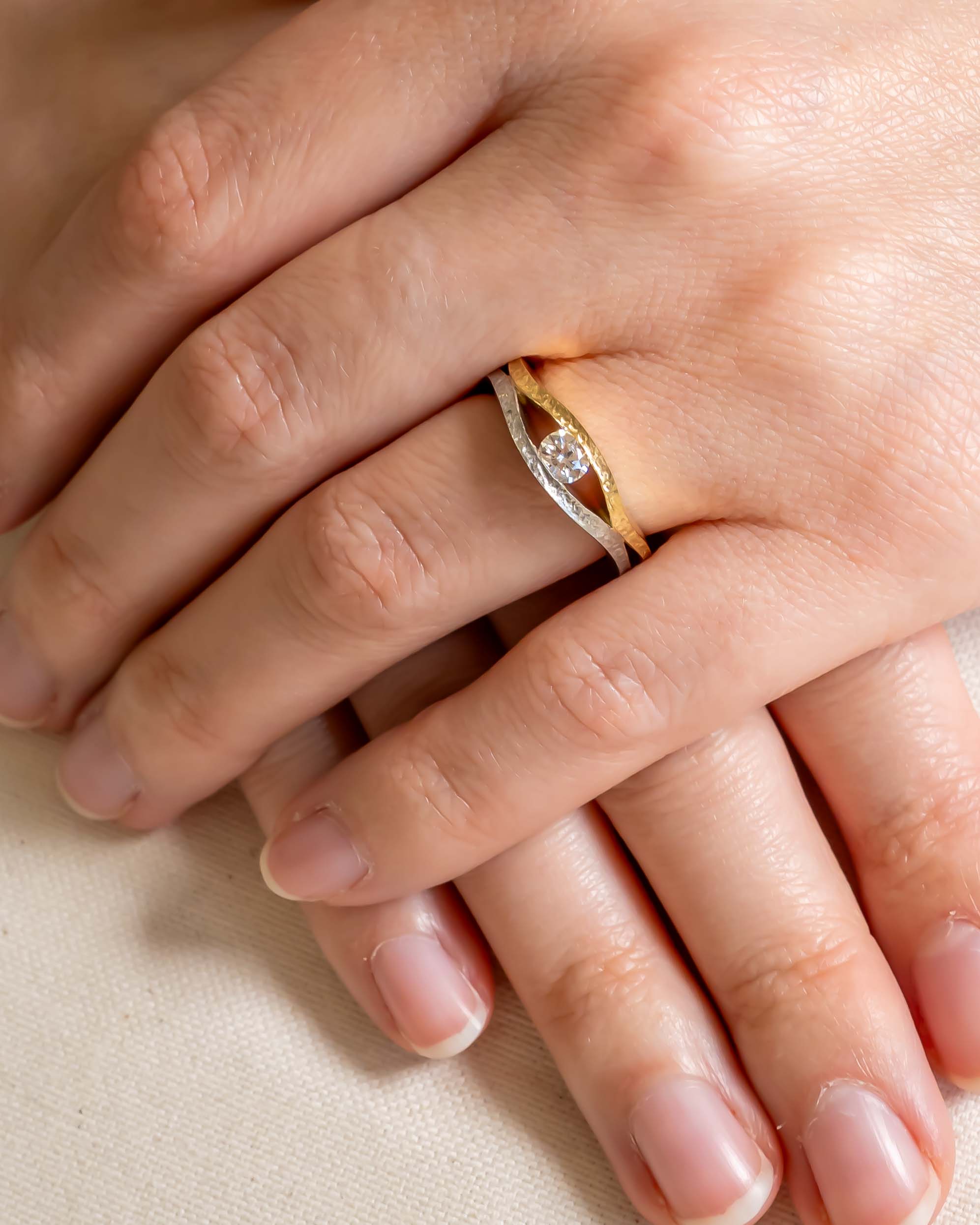 Rough hammered two-tone gold solitaire ring with a round diamond.