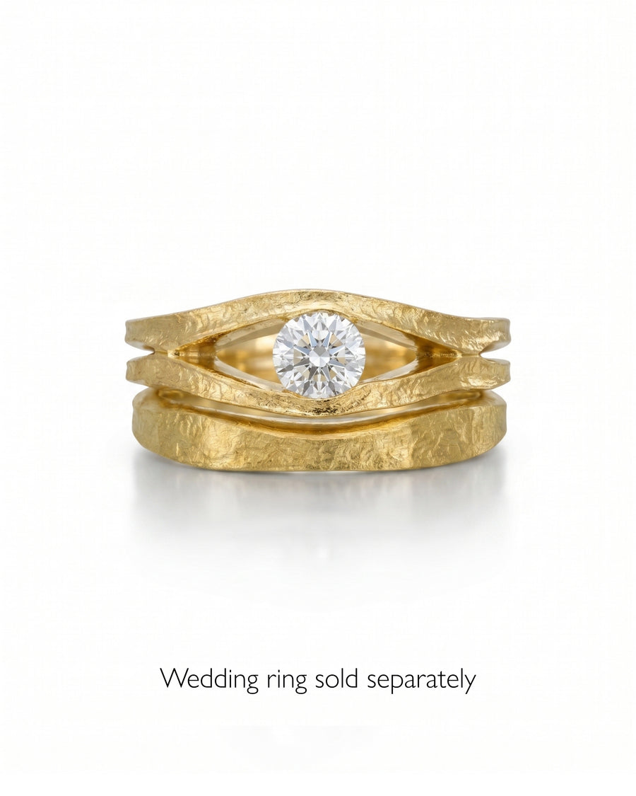 Rough hammered gold solitaire engagement ring with a round diamond.