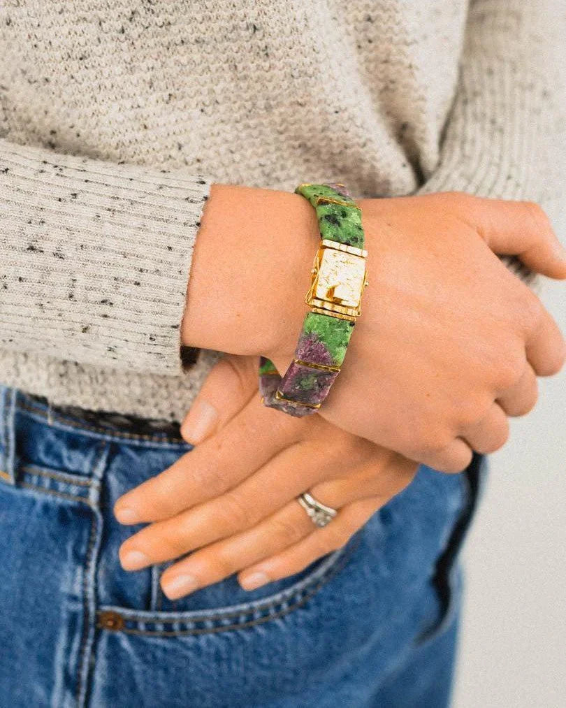 Rough ruby zoisite bracelet with gold clasp on wrist, casual sweater and denim style