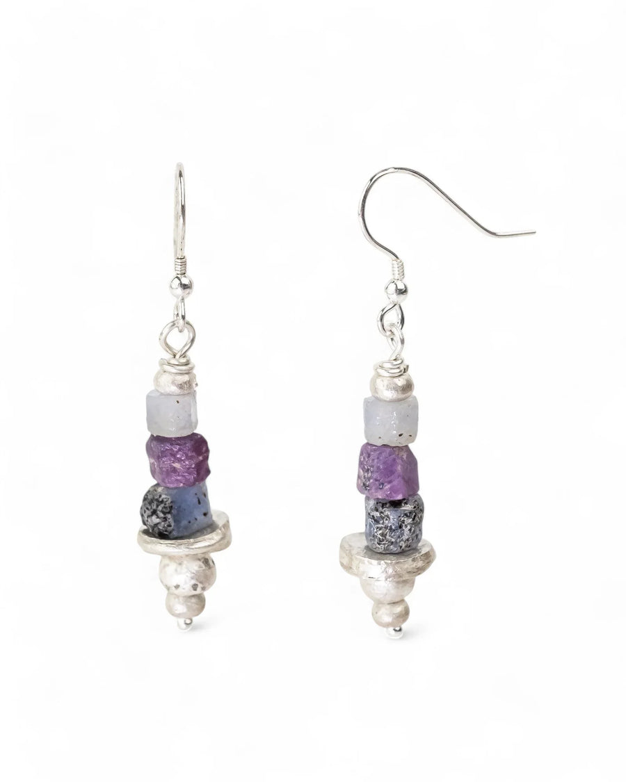 Silver dangle earrings with rough purple and blue sapphire beads.