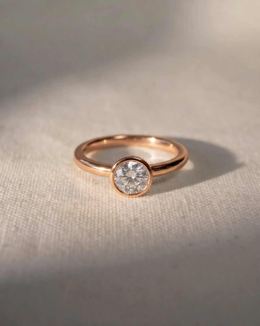 18ct rose gold engagement ring with a round cut lab-grown diamond in a bezel setting.