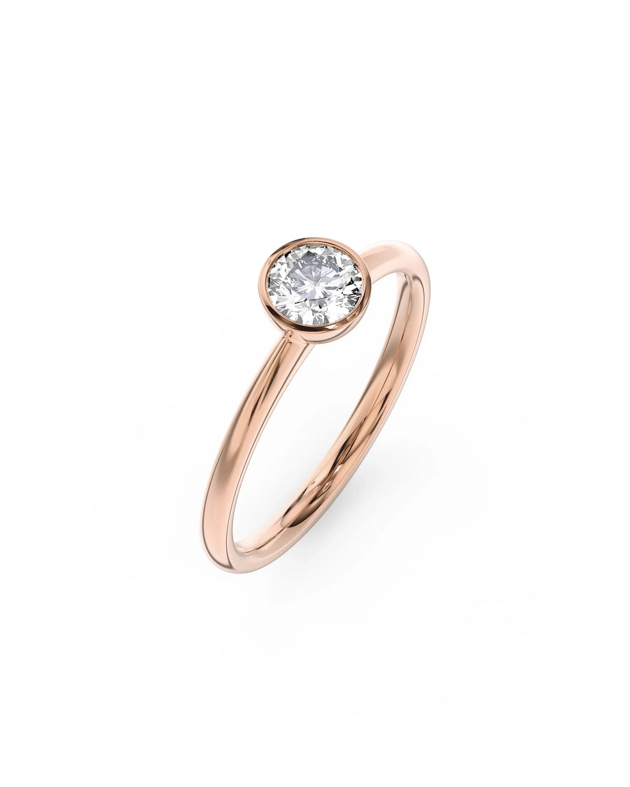 Rose gold engagement ring with a round cut natural diamond in a bezel setting.