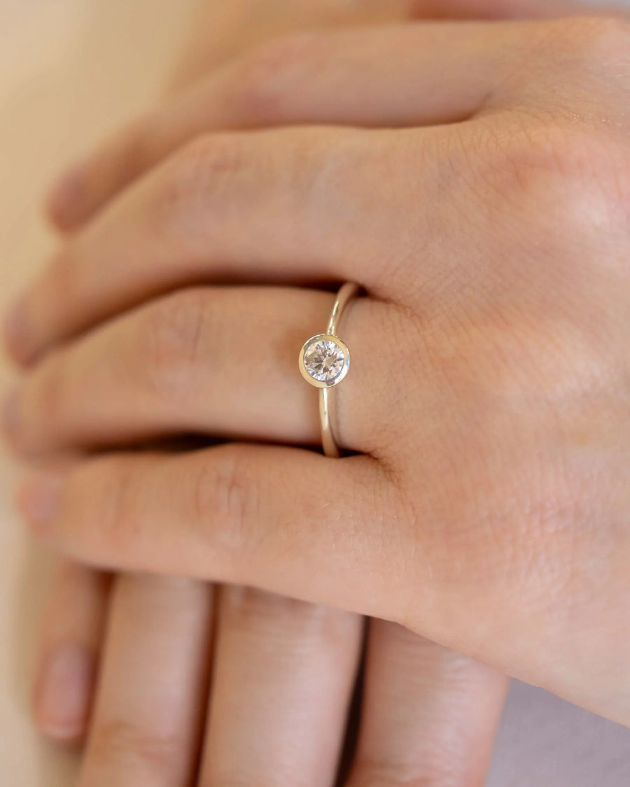 Yellow gold bezel engagement ring with a round cut natural diamond.