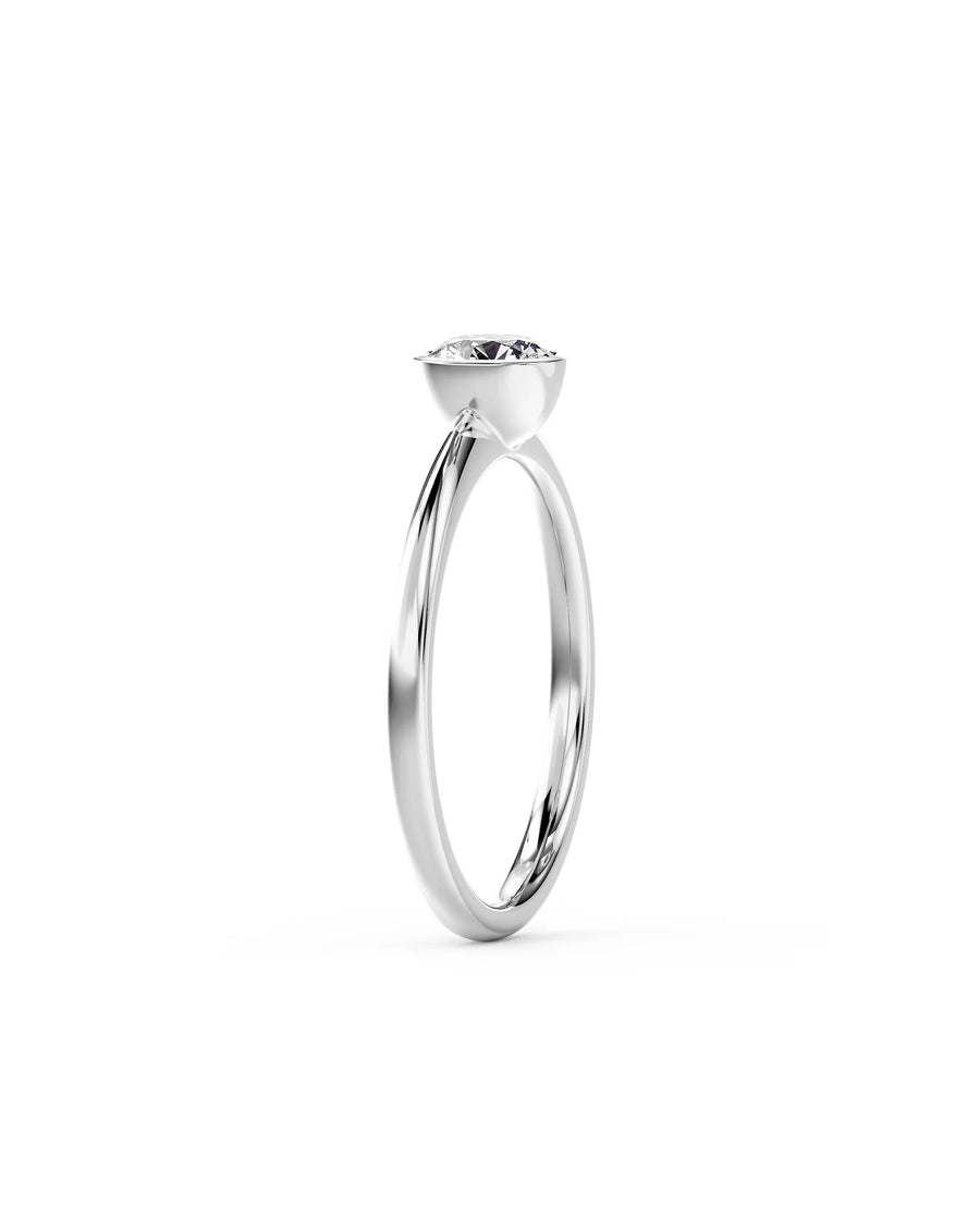 Silver round cut bezel engagement ring with a single diamond.