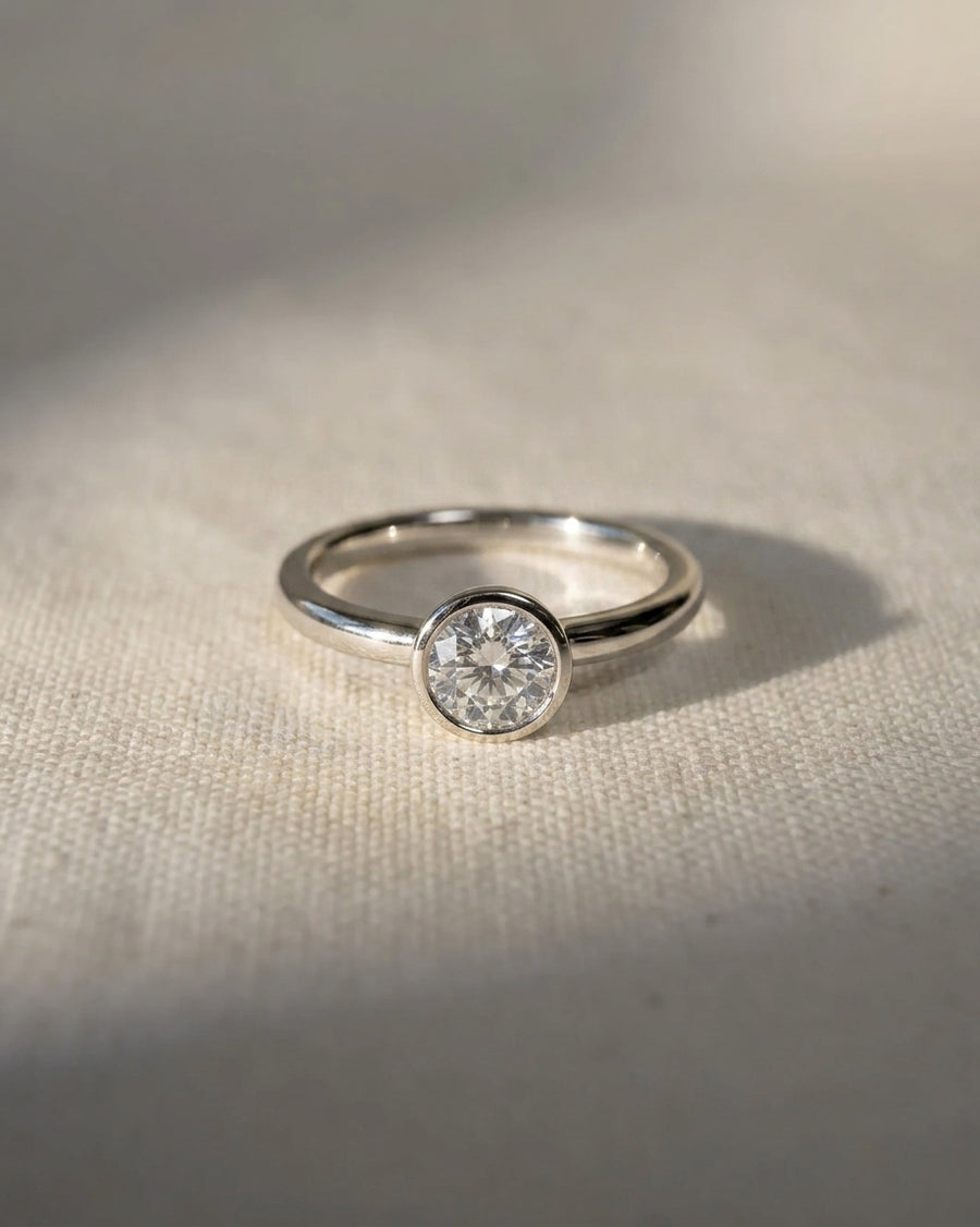 Platinum round cut bezel engagement ring with a lab-grown diamond.