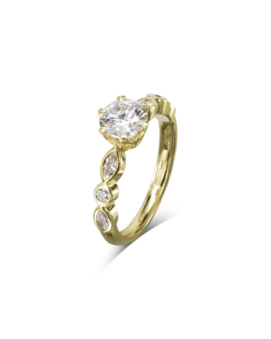 Gold engagement ring with a round cut diamond and marquise side stones.