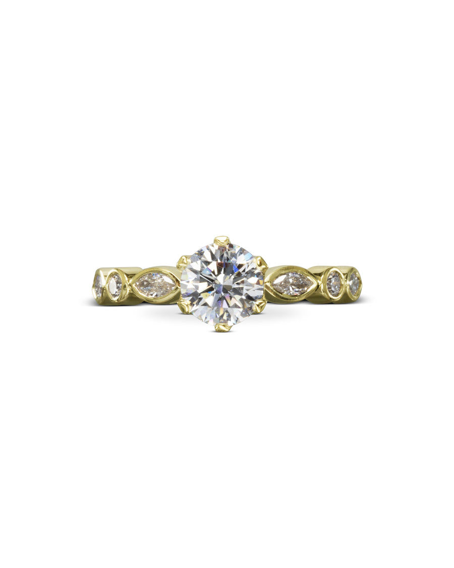 Yellow gold engagement ring with a round cut diamond and marquise side stones.
